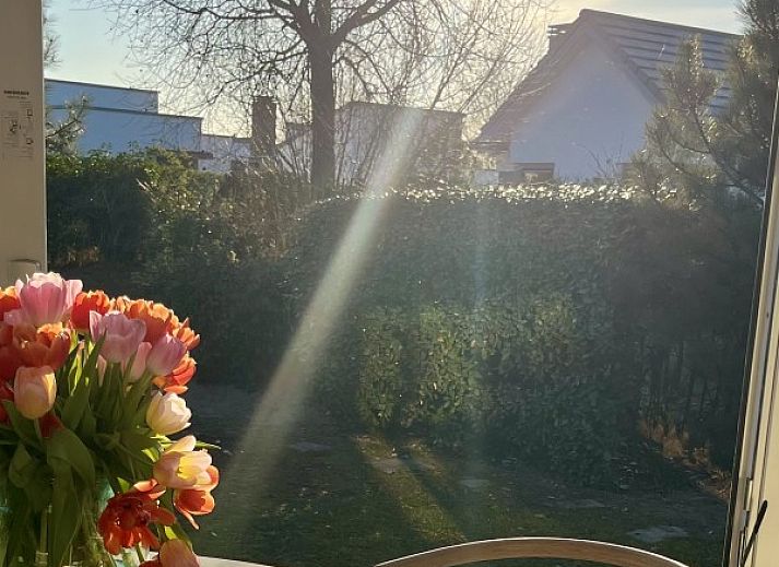 Sfeervolle slaapkamer in Strandhuis Over De Dam, Ouddorp, vakantiehuis met comfortabele bedden en tuinzicht op Goeree-Overflakkee.