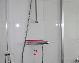 Moderne badkamer in Roggeslootweg 628 vakantiehuis, De Cocksdorp, Texel met luxe douche en strakke tegelafwerking.