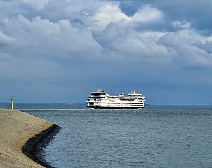 Uitzicht op de veerboot nabij Bed en Beach Wadbijzonder, Texel, met prachtige zee en wolkenlucht.