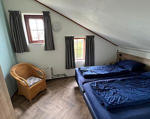 Ruime slaapkamer in Het Zonneveld vakantiehuis op Texel met veel natuurlijk licht.