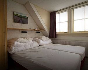 Comfortabele slaapkamer in bungalow Duif op Texel met twee bedden.