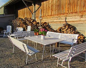 Speelplaats bij Hof ter Harte vakantiehuis, Ieper, West-Vlaanderen met schommel en glijbaan op groene grasveld.