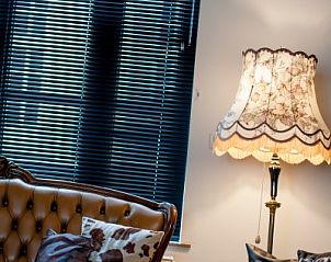 Comfortabele zithoek met leren bank in Huis 7, vakantiehuis Ieper, West-Vlaanderen.