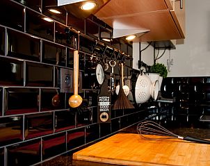 Moderne keuken met zwarte tegels in Huis 7, vakantiehuis Ieper, West-Vlaanderen.