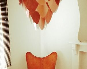 Stijlvolle hoek met designstoel in Huis 7, vakantiehuis Ieper, West-Vlaanderen.