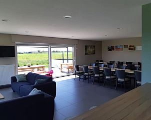 Gezellige woonkamer met grote ramen in 't Amusement, Ieper.