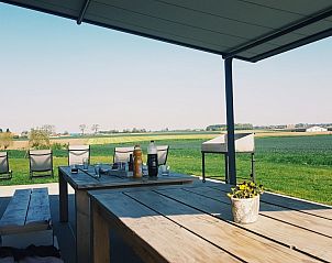 Terras met eettafel en uitzicht op landschap bij 't Amusement, Ieper.