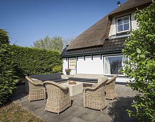 Comfortabel terras bij Stolp Nieuw Bornrif, familiehuis in De Koog, Texel, omgeven door groen.