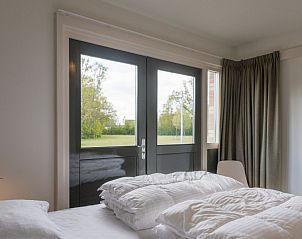 Luxe slaapkamer in Orchismient 24, De Koog, Texel met toegang tot terras en uitzicht op het groen.