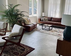 Lichte leefruimte in vakantiehuis Paal 234, De Koog, Texel, met comfortabele stoelen en grote ramen.