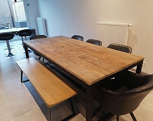 Ruime eetkamer met houten tafel en stoelen in THE FRONT DOOR N28, vakantiehuis in Ieper, West-Vlaanderen.