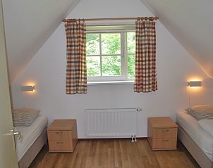 Tweepersoons slaapkamer in De Prins, Texel, met uitzicht op weelderige natuur.