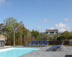 Verlicht zwembad bij nacht in Huize 100-1, vakantiehuis in De Koog, Texel, voor een sfeervolle avond.