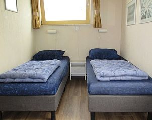 Tweepersoonskamer in huisje 149, De Koog, Texel, met comfortabele bedden en een serene ambiance op de Waddeneilanden.