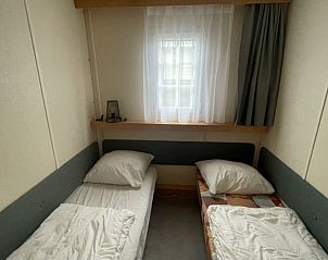 Sfeervolle slaapkamer met twee bedden in chalet Bayahibe, De Koog, Texel, Waddeneilanden.