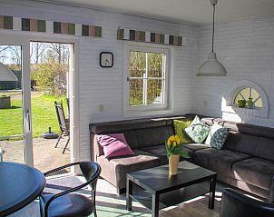 Lichte zithoek in 't Langebosch bungalow, Dennenbos, Texel met uitzicht op de tuin, perfect voor een vakantie op de Waddeneilanden.