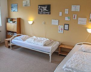 Sfeervolle slaapkamer in bed and breakfast de Eierdop, De Cocksdorp, Texel met kunst aan de muur en comfortabele bedden.