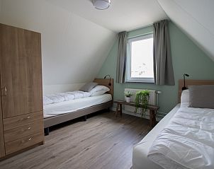 Ruime slaapkamer met twee eenpersoonsbedden in Nieuwlanderweg 75 bungalow, De Koog, Texel, ideaal voor gezinnen.