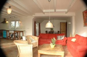 Gezellige woonkamer in Alexanderhoeve, Den Hoorn Texel, met comfortabele banken en open keuken voor een huiselijk verblijf op de Waddeneilanden.