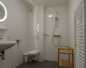 Moderne badkamer in De Vigilant vakantiehuis, Den Hoorn, Texel met inloopdouche, ideaal voor een comfortabel verblijf op de Waddeneilanden.