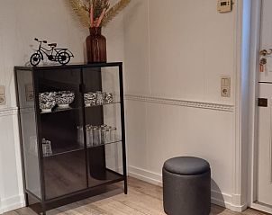 Sfeervolle entree met decoratieve kast in Bruinverhuurt Oudeschild, vakantiehuis in Oudeschild, Texel voor een warm welkom.