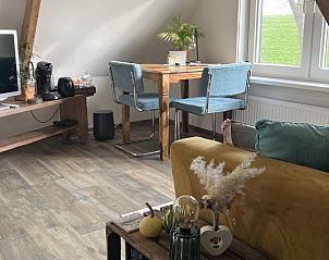 Eethoek met houten tafel in B&B de witte punt Texel, Oudeschild, met uitzicht op de natuur.