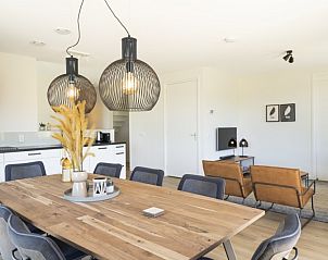 Interieur van Rovershut - Familiehuis 1 in Dennenbos, Texel. Moderne eetkamer in vakantiehuis met ruime eettafel en stijlvolle verlichting.