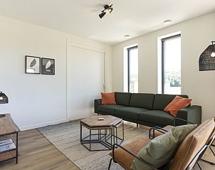 Gezellige woonkamer in Rovershut - Familiehuis 1, een vakantiehuis in Dennenbos, Texel. Comfortabele zithoek met natuurlijk lichtinval.