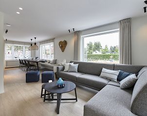 Ruime woonkamer van Vakantievilla Marie-Arthur in Koksijde-bad, Belgische kust, met grote ramen en comfortabele zithoek.