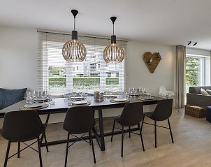 Eetkamer in Vakantievilla Marie-Arthur, Koksijde-bad, Belgische kust, met sfeervolle verlichting en een groot raam.