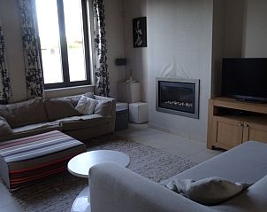 Gezellige woonkamer van maison Miest vakantiehuis in Watou, West-Vlaanderen met comfortabele banken en open haard.