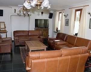 Comfortabele woonkamer in 't Leeghuys vakantiehuis in Lo-Reninge, West-Vlaanderen, met lederen meubels.