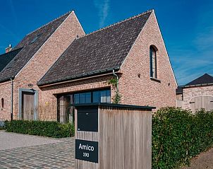 Charmant vakantiehuis in Gistel, Belgi met houten hek en groene haag, perfect voor een rustige vakantie in West-Vlaanderen.