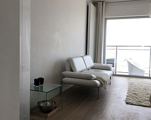 Stijlvolle binnenruimte met balkonzicht in Vakantie aan Zee appartement, Knokke-Heist, West-Vlaanderen.