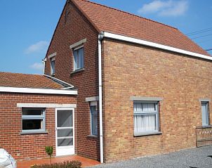 Achteraanzicht van Remabo vakantiehuis in Bovekerke, West-Vlaanderen, met zonnig terras en bakstenen muren.