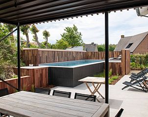 Ruim terras bij Villa Atha, vakantiehuis in De Panne, met uitzicht op het zwembad en groene omgeving.