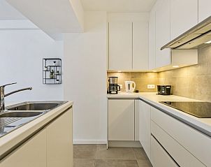 Moderne keuken in Flat Antoine, appartement in De Panne, West-Vlaanderen, met strakke lijnen en hoogwaardige apparatuur.