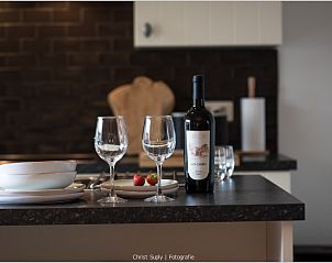 Gezellige opstelling met wijn en glazen in de keuken van MURKERKA vakantiehuis in Damme, West-Vlaanderen.