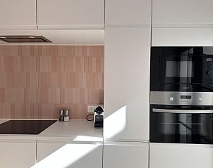 Stijlvolle keukenapparatuur in Villa Frans Lichtrijk Appartement 2 slpk, Oostende, West-Vlaanderen, met moderne oven en koffiezetapparaat.