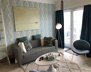 Comfortabele woonkamer in Mamre Beach Condo, Oostende met een gezellige bank en sfeerverlichting.