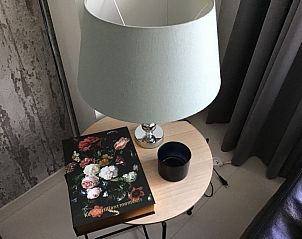 Stijlvolle hoek met tafellamp en boek bij Residentie Magnolia appartement in Westende, Belgi.