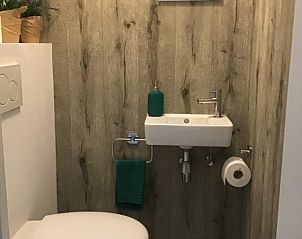 Compacte badkamer in Residentie Magnolia appartement Westende, Belgi met houten wand.