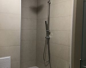 Moderne badkamer met douche en bad in Residentie Magnolia appartement Westende, Belgi.