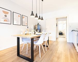 Moderne eetkamer van Huisje in Wildemann, Harz, Nedersaksen, met sfeervolle lampen en strakke meubels.