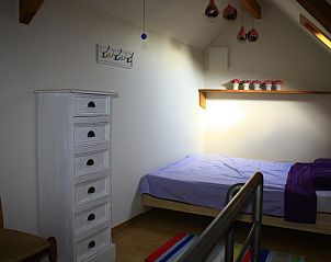 Slaapkamer met eenpersoonsbed en houten meubels in De Mutsaard, Oost-Vlaanderen, Belgi.