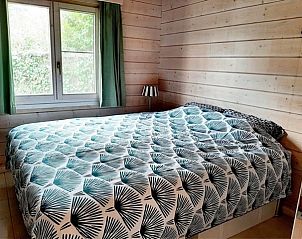 Comfortabele slaapkamer in chalet Au Repeau, Moerzeke, Oost-Vlaanderen met uitzicht op de tuin.