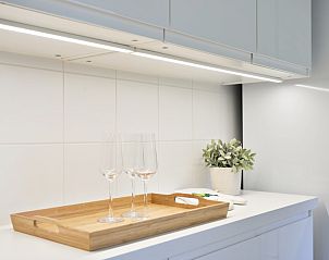 Detail van de keuken in Bellovisto vakantiehuis, Vlaamse Ardennen, Oost-Vlaanderen, met elegante glazen en dienblad.