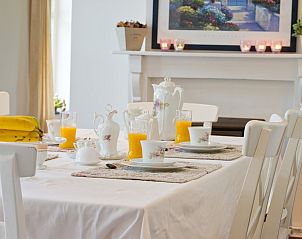 Gezellig gedekte ontbijttafel in Bellovisto vakantiehuis, Vlaamse Ardennen, Oost-Vlaanderen, met vers fruit en sap.