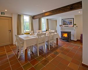 Ruime eetkamer met open haard in Bellovisto vakantiehuis, Vlaamse Ardennen, Oost-Vlaanderen, ideaal voor diners.