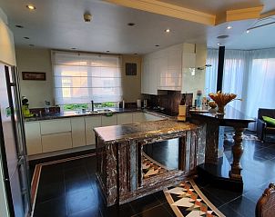 Moderne keuken in Hoeve Hoogeind, Sint-Gillis-Waas, met marmeren eiland en stijlvolle inrichting, perfect voor culinaire liefhebbers in Oost-Vlaanderen.